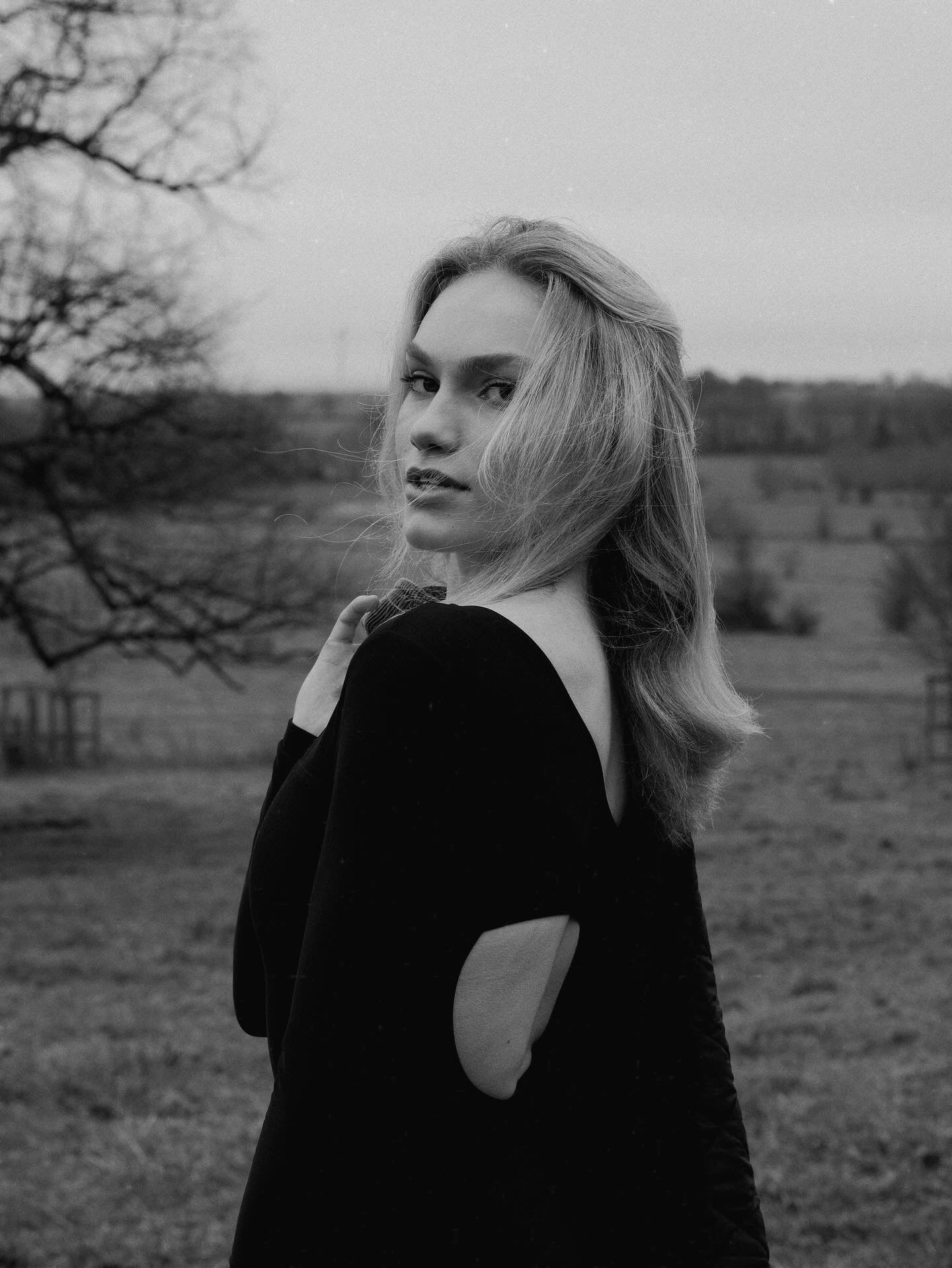 Black and white photo of a person wearing Skaet thermals with a scenic British countryside background