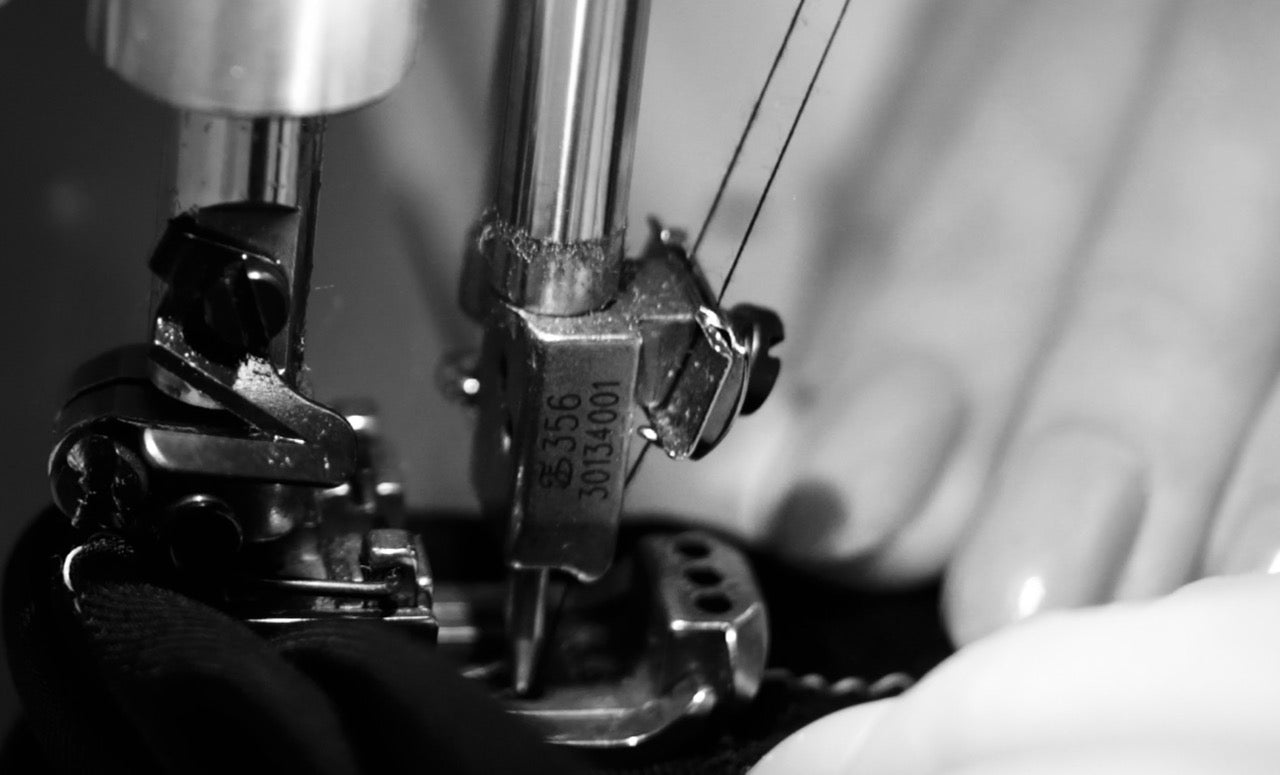 Close-up of a sewing machine needle and thread in black and white.