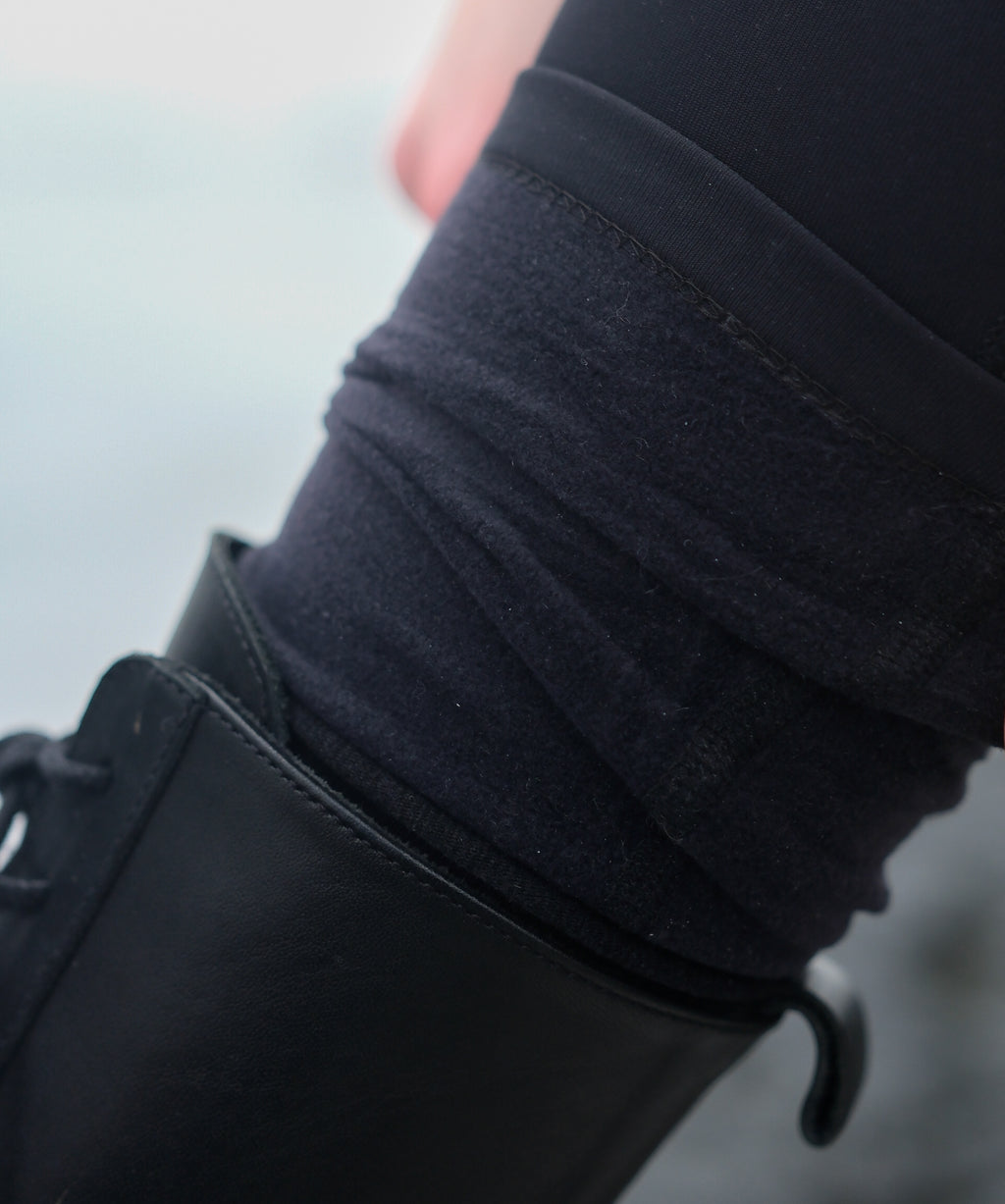 A picture of the hem of thermal leggings folded up with the fleece-lining showing against a smooth leather boot.