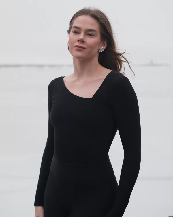 The front image of the Petal Bodysuit by Skaet. It shows an elegant neckline that is asymmetrical as part of the stylish design.